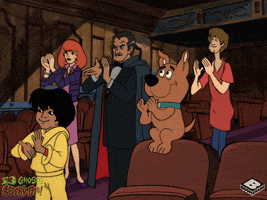 Cartoon gif. Flim-flam, Daphne, Vincent Van Ghoul, Scrappy-Doo, and Shaggy, from "The 13 Ghosts of Scooby-Doo," in a theater and giving a standing ovation.