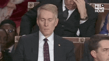 Political gif. James Lankford sits in the audience at the State of the Union. His expression is stoic as he blinks and nods slowly.