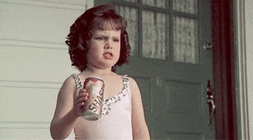 Movie gif. Brittany Ashton Holmes as Darla in Little Rascals wears a pink leotard and crunches a soda can in her hand as if intimidating someone.