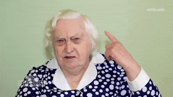 TV gif. From Most Expensivest, a white-haired old woman frowns and appears confused, pointing to and then cupping her hand behind her ear to show she can't hear.