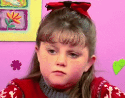 Video gif. A young girl shrugs her shoulders and frowns. 