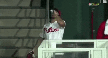 Sports gif. Phillies pitcher is completely amped up as he crushes an energy drink can against his glove before running onto the field.