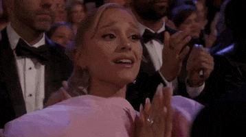 Oscars 2024 GIF. Ariana Grande, at the Oscars, applauds with dainty girlishness, then cups her hands and cheers. 