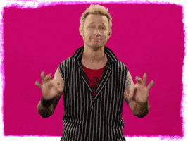 Celebrity gif. Mike Dirnt from Green Day sends us a double OK hand symbol with his mouth turned down in a satisfied pout.