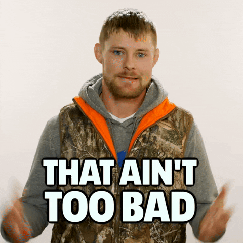 Video gif. Bryce Mitchell, a UFC fighter, shakes his head and raises his hands as he says, "That ain't too bad" with a matter of fact expression. He's wearing a camo vest and standing in front of a beige background.