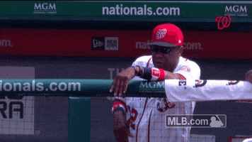Sports gif. Dusty Baker with the Washington Nationals stands in the dugout and tosses his ball cap to the ground as if in anger and looks over the field. 