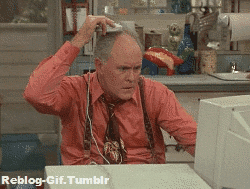 TV gif. Looking perplexed, John Lithgow as Dick on 3rd Rock from the Sun sits in front of a computer, rolling a computer mouse on his head.