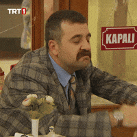 TV gif. A scene from Seksenler: Seated at a restaurant table, a man in a plaid suit with a moustache waves as if to say "don't worry about it", then makes a satisfied "chef's kiss" gesture.