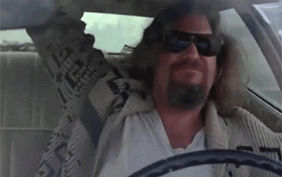 Movie gif. Jeff Bridges as the Dude in Big Lebowski wearing sunglasses, banging the roof like he's vibin' and drivin'.