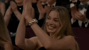 Oscars 2024 GIF. Margot Robbie, applauds, hands above her head for emphasis.