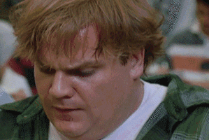 Movie gif. Chris Farley as Tommy in Tommy Boy looks worried until a flash of inspiration hits. He rolls his head with a confident smirk.