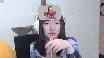 Video gif. A woman with cat whiskers painted on her cheeks wears headphones and stares off into space while holding a pair of chopsticks. A thought bubble contains a monkey clapping some cymbals together and doing backflips. 