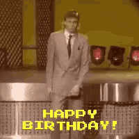 TV gif. A guy with a mullet, gray suit, and white sneakers, dances on an 80s game show, doing a whacky side-to-side dance, shuffling his feet and swinging his arms around. Text, "Happy birthday."