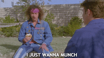 Movie gif. Sitting outside, Pauly Shore as Stoney Brown in Encino Man looks down at his bagel, and tells someone offscreen, "I just wanna munch," which appears as text.