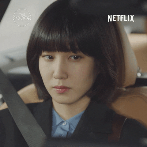 TV gif. Park Eun-bin as Woo Young-woo in Extraordinary Attorney Woo. She's sitting in the passenger seat of a car and slowly peers at the driver, trying to gauge their mood.