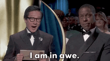 Oscars 2024 GIF. Split screen of Ke Huy Quan applauding and saying to Sterling K Brown, “I am in awe.”