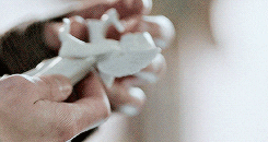 Video gif. Hands gently hold a small white angel figurine as if in reverence.
