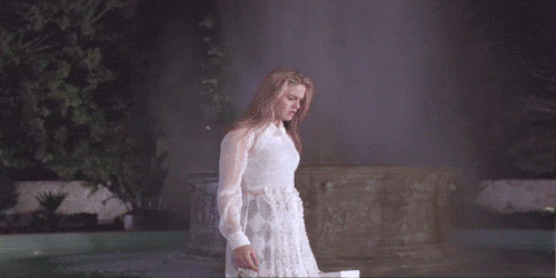 Alicia Silverstone as Cher in Clueless, having a major epiphany as the fountain behind her lights up