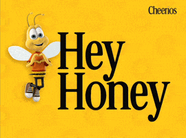 Sponsored gif. Buzz, the anthropomorphic bee mascot for Cheerios, floats gently up and down while smiling and holding his hands in the shape of a heart. The Cheerios logo is in the upper right corner, and dark yellow Cheerio shapes float by on the yellow background. Text reads: Hey Honey