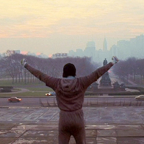 Movie gif. Sylvester Stallone as Rocky in Rocky holds his arms above his head in triumph over the city of Philadelphia. A rainbow appears over him with the message, “The PA election matters.”