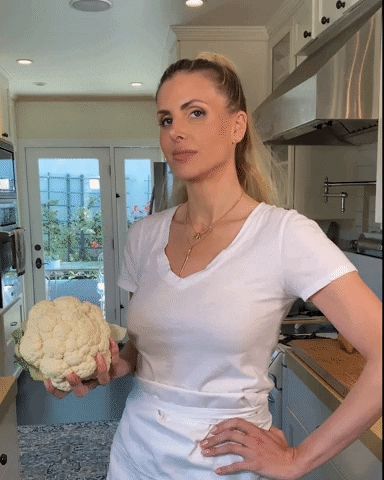 Woman preparing healthy vegetables in kitchen representing PCOS-friendly cooking