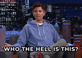 Tonight Show gif. Tig Notaro relaxed in her seat, arms wide in query, demands "Who the hell is this?"