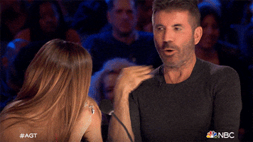 Reality TV gif. Simon Cowell on America's Got Talent. He shakes his head and uses his hand to wave a hand at his neck, adamantly saying no. 
