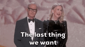 Oscars 2024 GIF. Catherine O'Hara and Michael Keaton stand at the podium, announcing the nominees for Best Makeup and Costume. O'Hara looks around the crowd and shrugs her shoulders as she sweetly says, "The last thing we want is anyone knowing what we really look like." Keaton solemnly nods in agreement. 