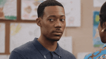 TV gif. Tyler James Williams as Gregory from Abbott Elementary looks around nervously before staring straight at us.