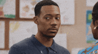 TV gif. Tyler James Williams as Gregory from Abbott Elementary looks around nervously before staring straight at us.