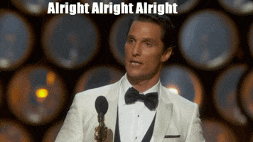 Celebrity gif. Wearing a white tuxedo, Matthew McConaughey speaks into a microphone while holding up an Oscar award. Text, "Alright Alright Alright."