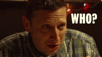 Celebrity gif. A confused Tim Robinson leans forward and asks, “Who?”