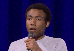 Celebrity gif. Donald Glover doing stand-up pauses with a blank look, then speaks sharply with widened eyes. Text, Good.