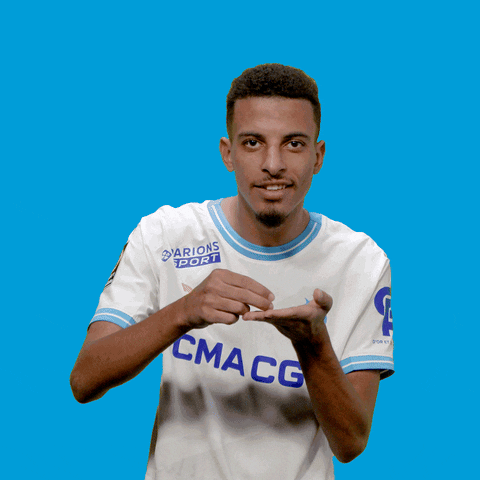 Sports gif. Azzedine Ounahi, a soccer player for the Olympique de Marseille uses his hands to pretend he's holding an espresso cup and plate. He grins and air sips from the teacup.