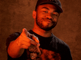 Celebrity gif. Musician Kevin Abstract of Brockhampton pats his heart and points to the viewer in a gesture of love and respect. Magenta and yellow squiggly lines explode from his hand as he points. 