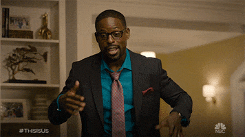 TV gif. Sterling K Brown as Randall on This Is Us wiggling his head and hands in a happy, teasing manner.
