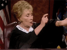 TV gif. Judge Judy dramatically points to her wristwatch and then pounds on the bench.