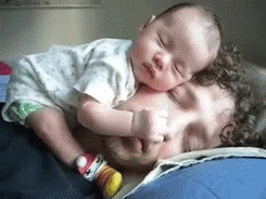 Gif se spícím tatínkem, na kterém leží a spinká malé miminko.