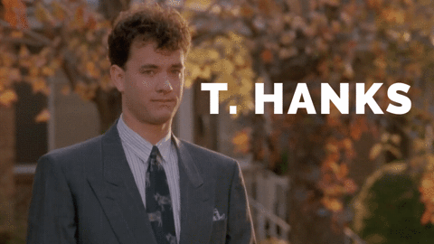 Movie gif. Tom Hanks as Josh in Big. He puts a hand up and waves endearingly but stiffly and the word, "T.HANKS" pops up next to him. When he raises his hand, we see his first initial and last name, giving the word two meanings.