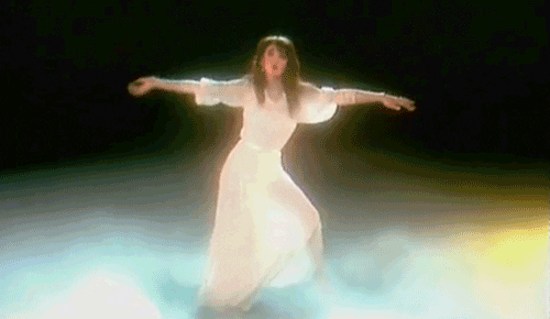Gif of Kate Bush dancing in the Wuthering Heights music video wearing a flowing white dress. 