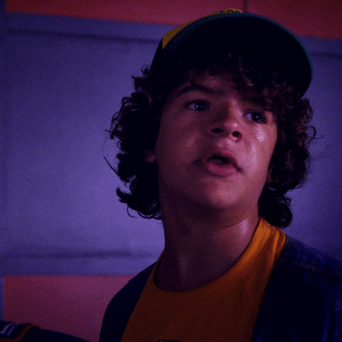 TV gif. Gaten Matarazzo as Dustin on Stranger Things looking annoyed and shocked. Text, "Holy mother of god."