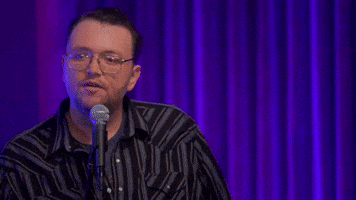 Celebrity gif. Sam Tallent, a comedian, is doing a standup skit and he wears a striped shirt and glasses while saying, "My wife's like a hot lady, you know? And I look like this all the time, alright?"
