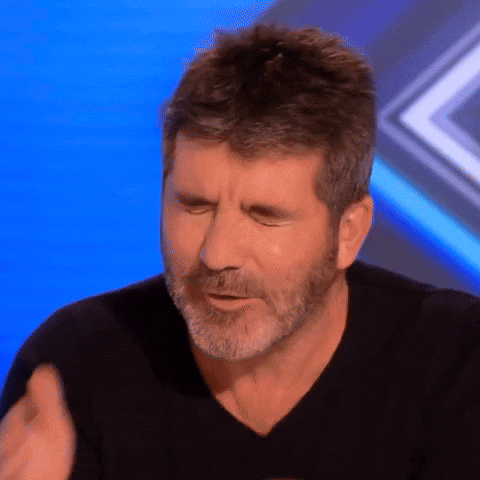 TV gif. Simon Cowell as host of X Factor cringes with his eyes closed, then covers his face with his hands. 