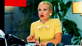 Movie gif. A scene from Down with Love where the receptionist goes light headed and faints. Her eyes lose focus and she topples backwards in her office chair, and we see the bottoms of her yellow heels popping into the air.