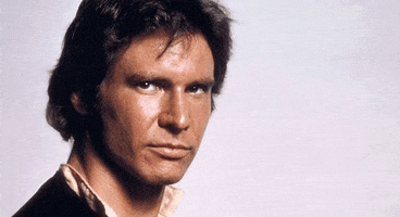 Photo gif. A hand giving a thumbs-up appears in front of a photo of Harrison Ford.