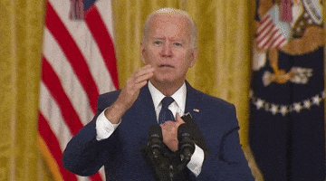 Political gif. Joe Biden stands at the White House podium. He looks at us with a hand out like he was about to say something, but then he bows his head and puts his mouth on his hands that hold a book. He looks like he’s praying or trying to keep himself composed.