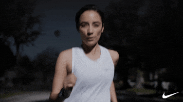 Ad gif. Woman wearing Nike gear runs enthusiastically on the street at night and gestures encouragingly as if to say, “Let’s go.”