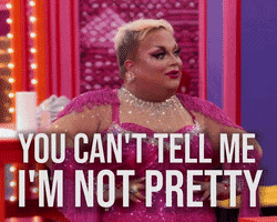 Reality TV gif. A Drag Queen on Rupaul’s Drag Race stands with their hands on their hips in a bedazzled bodysuit and glam makeup painted on their face. They say, “You can't tell me I'm not pretty,” and they look around the room confidently. 