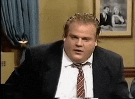 Celebrity gif. Chris Farley is in a suit and is sitting in a chair when all of a sudden, he gets a terrified look on his face and he shakes his hands in fear before clutching his forehead.
