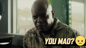 Movie gif. Samuel L. Jackson as Darius in The Hitman's Wife's Bodyguard gives a hard stare to someone off screen, tightening the line of his mouth, as we move into a closeup of his face. The text is next to a frowning smiley face. Text, "You mad?" 